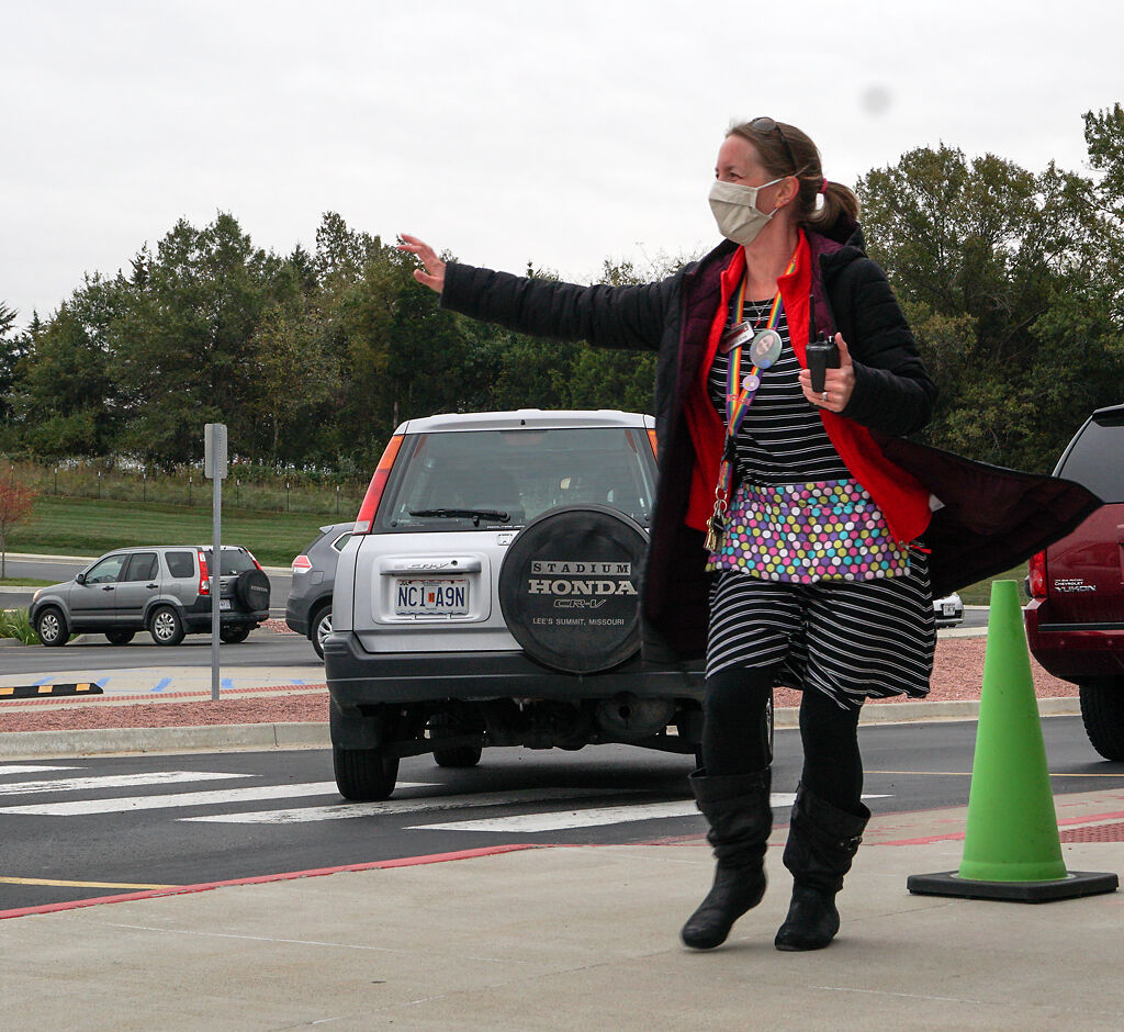 Cedar Ridge Elementary School counselor Jennifer Boyer signals for a car to pull forward